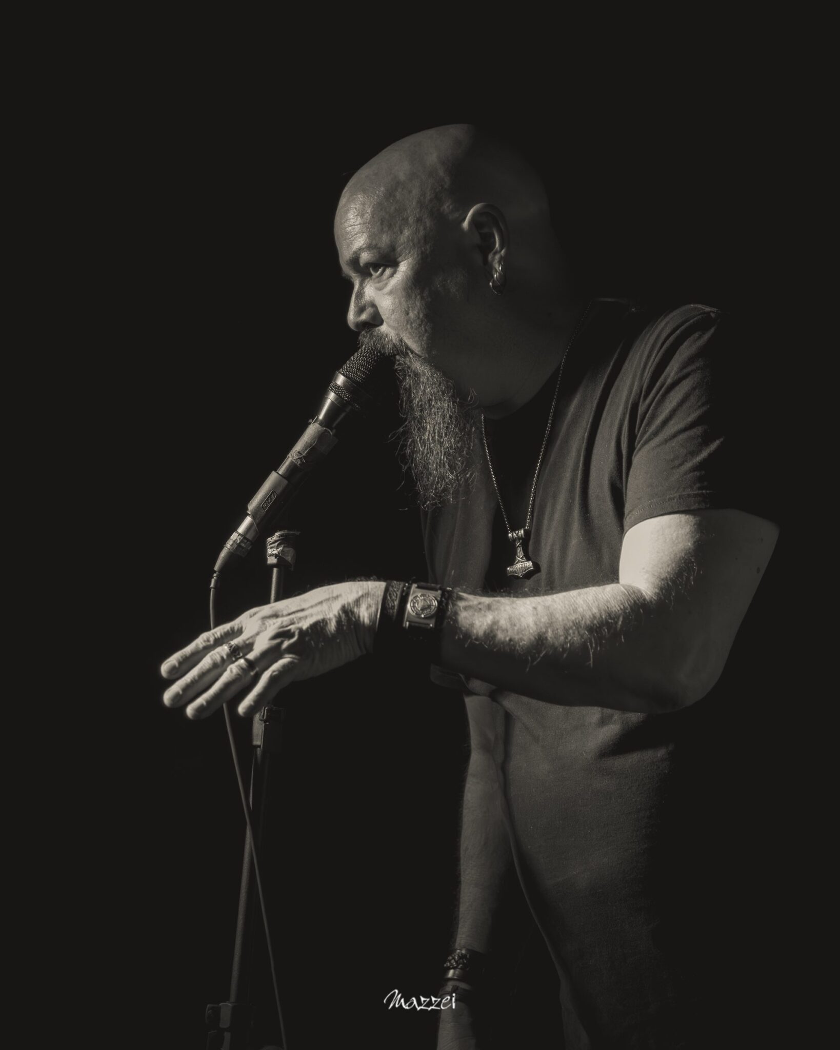 Robert Lowe reaching toward the microphone stand, black and white